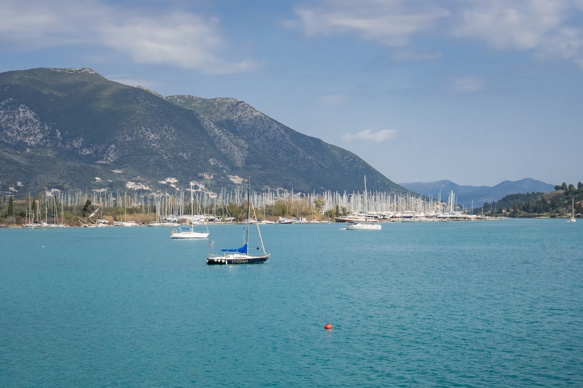 White sailing yacht anchored in a turquoise cove among Greek islands