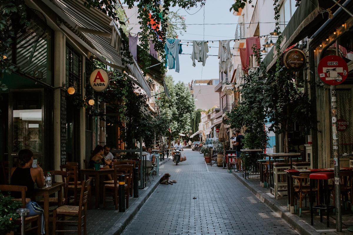 Narrow street in Athens lined with cafe tables and outdoor seating