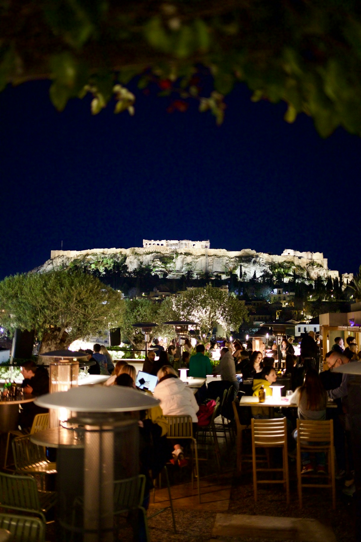 Rooftop bar in Athens at night with the Acropolis lit up in the background