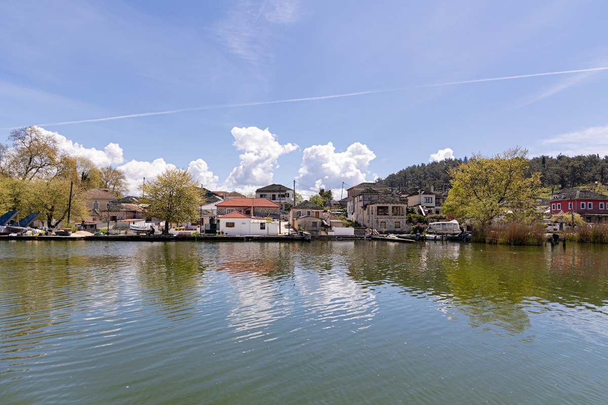 Lakeside houses and trees reflected in Lake Pamvotis, Ioannina, Greece