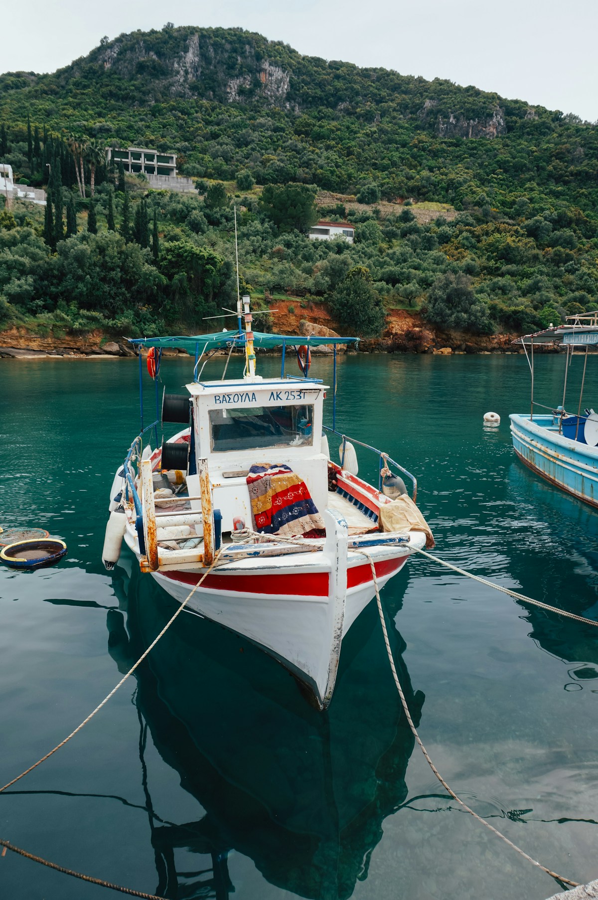 White boat tied to a pier in calm waters at Kalamata harbour, Greece