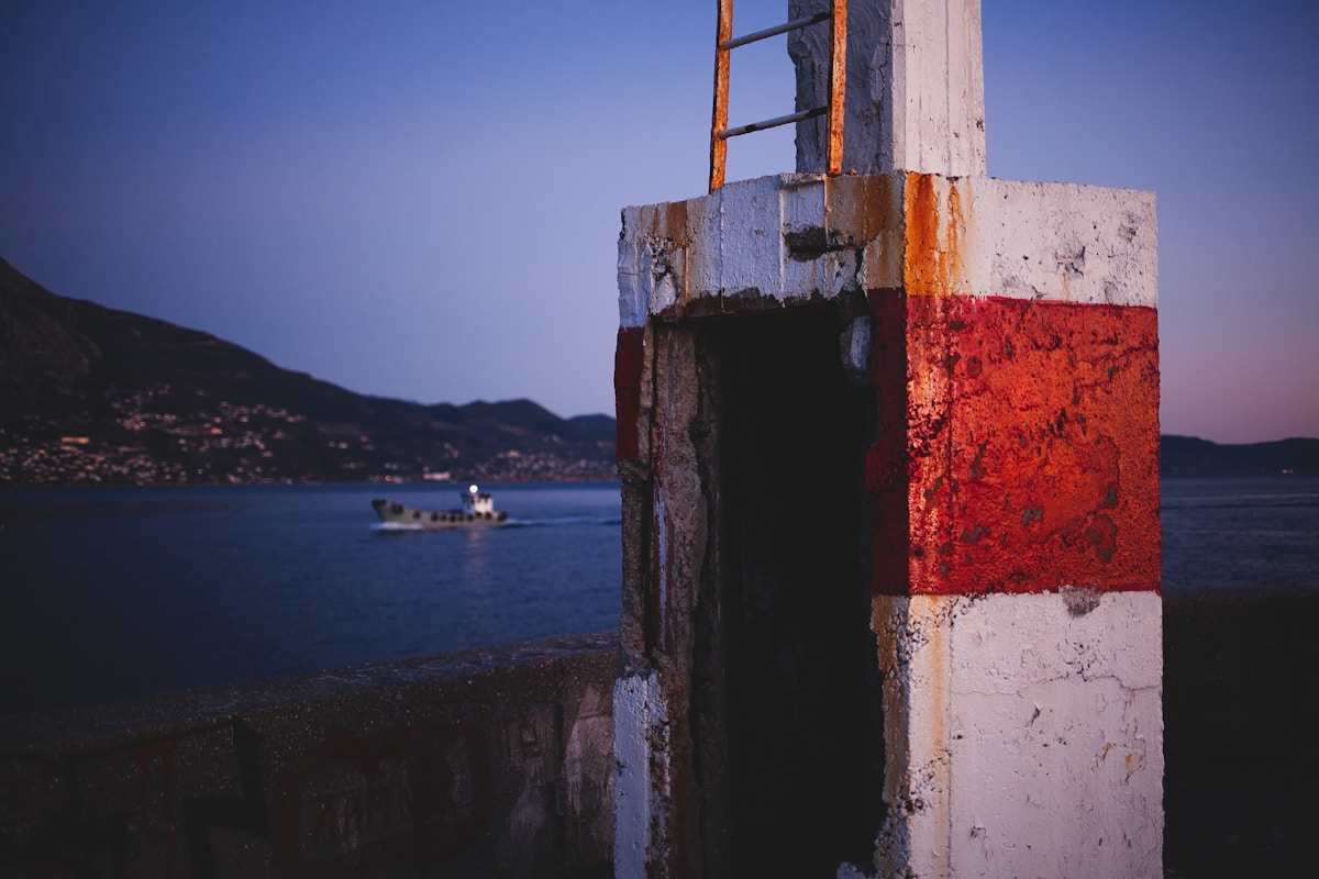 Kalamata harbour at dusk with a boat on the water and mountains behind
