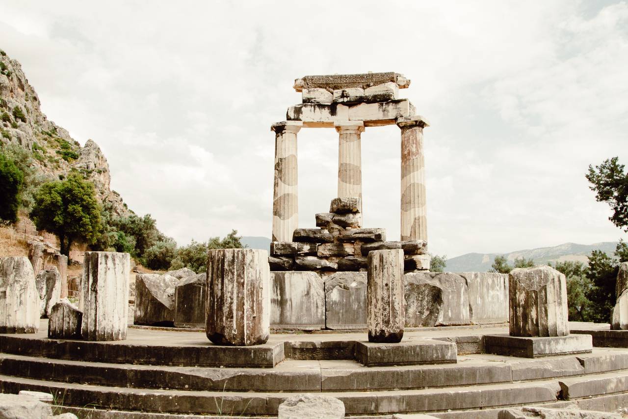 The Temple of Apollo at Delphi on a hillside above the Sacred Way, with mountains stretching into the distance