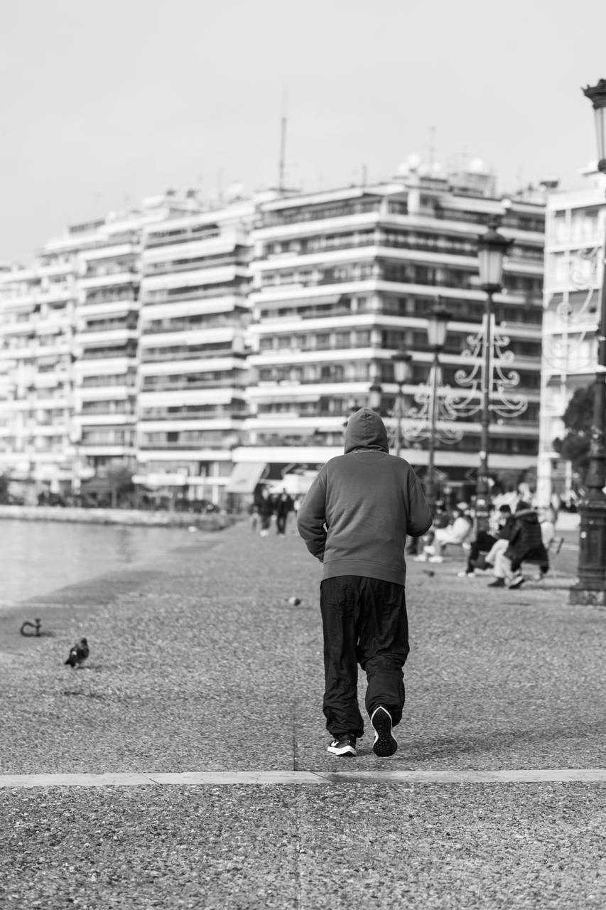Person walking along the Thessaloniki waterfront on the Thermaic Gulf with the city skyline behind