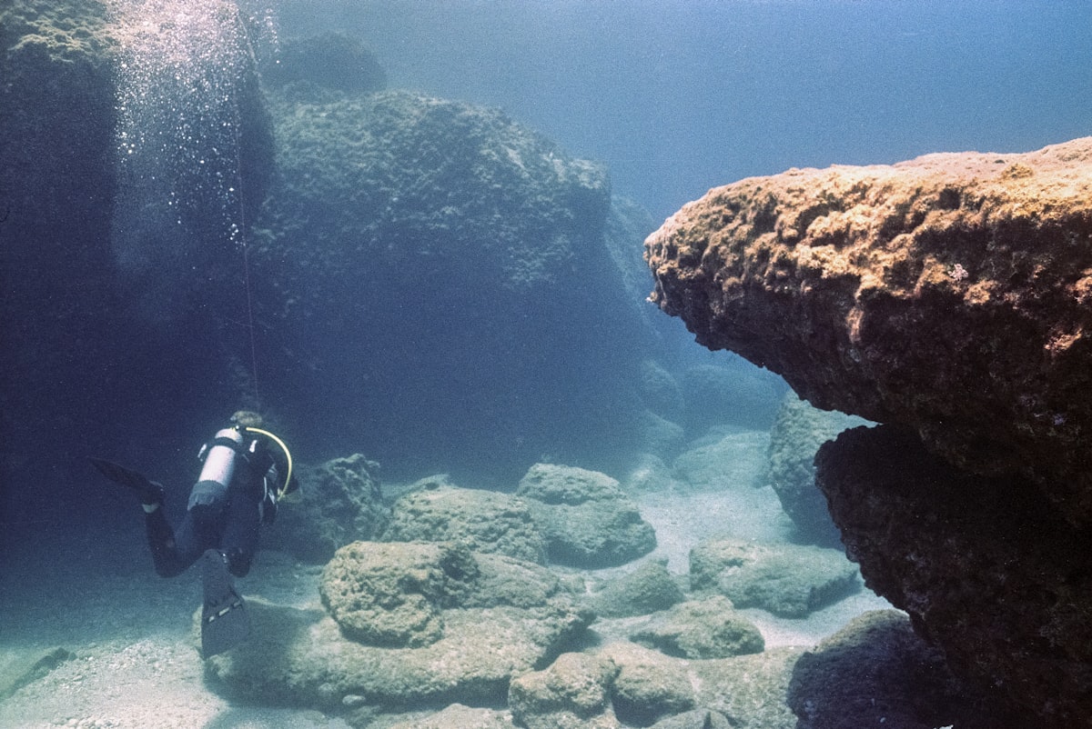 Diver exploring an underwater reef in the clear blue waters of Greece