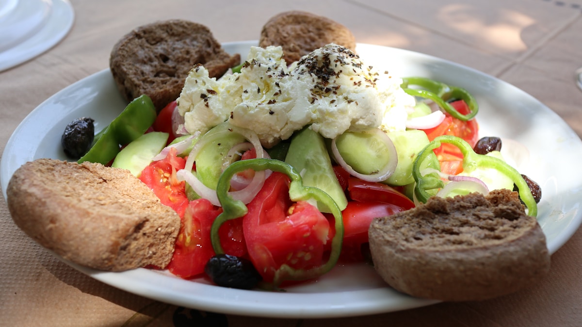 Traditional Greek salad with feta cheese and barley rusks on a white plate, Crete
