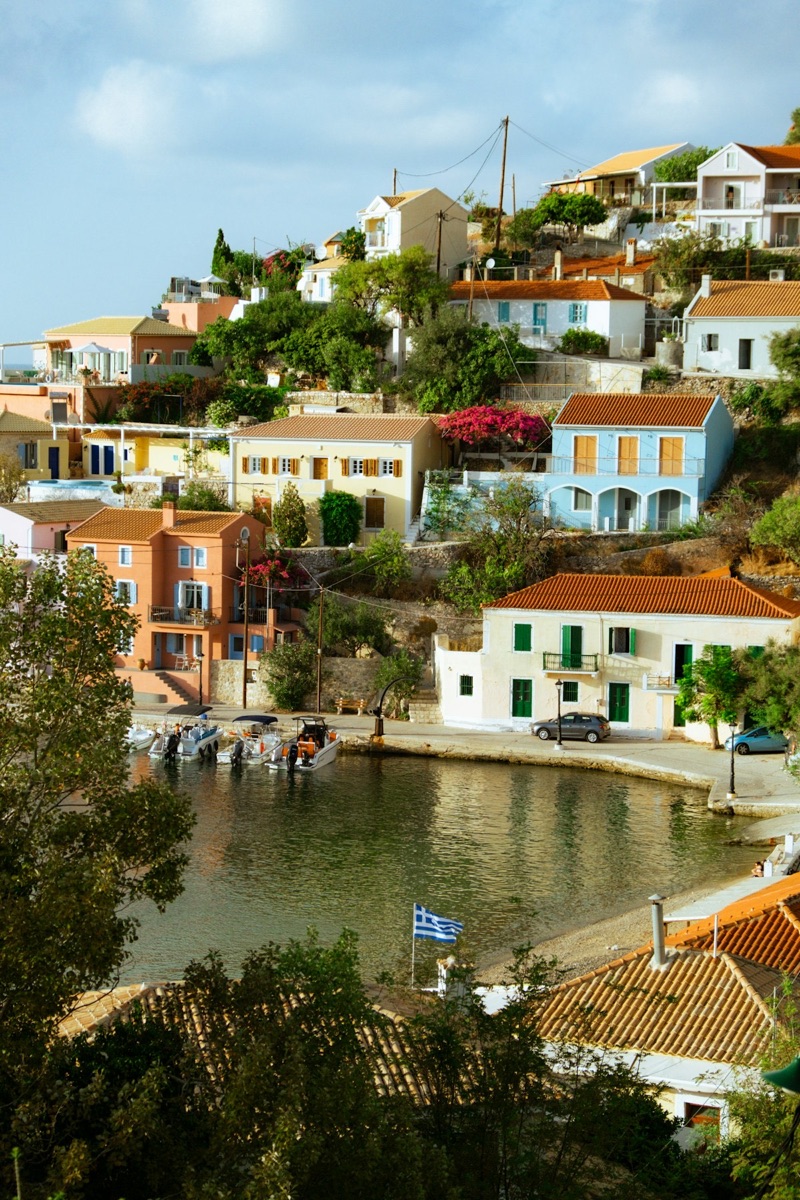 Colourful village houses on a hillside above a small harbour, Assos, Kefalonia, Greece