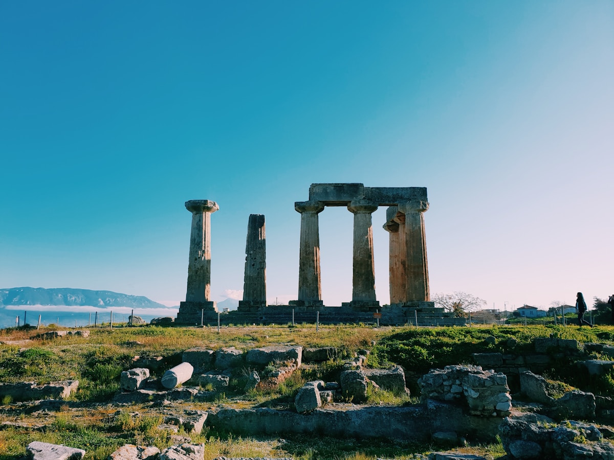 The Temple of Apollo at Delphi with columns standing against the mountain backdrop