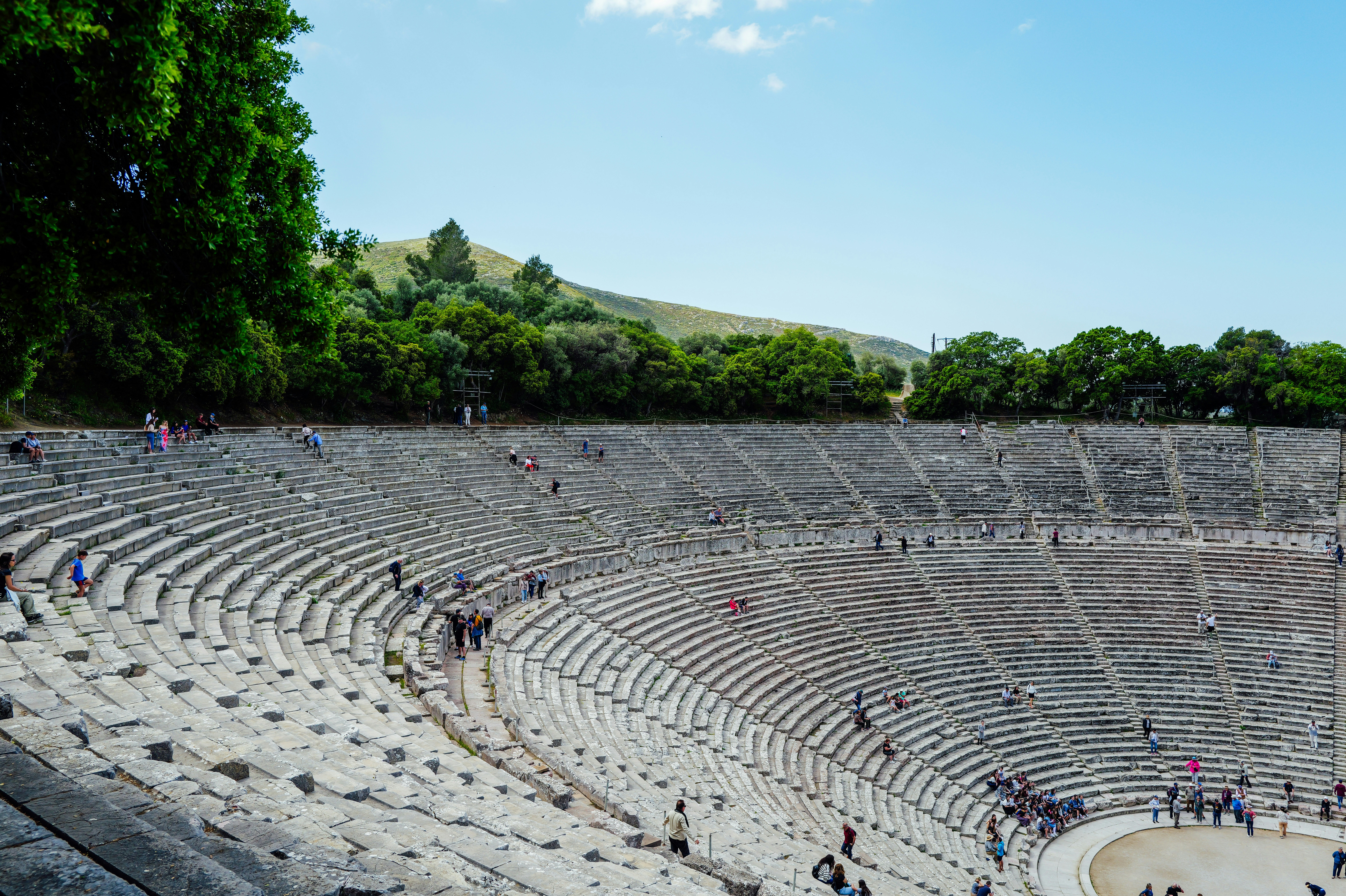 The perfectly preserved ancient theatre of Epidaurus with tiered stone seating and forested hills