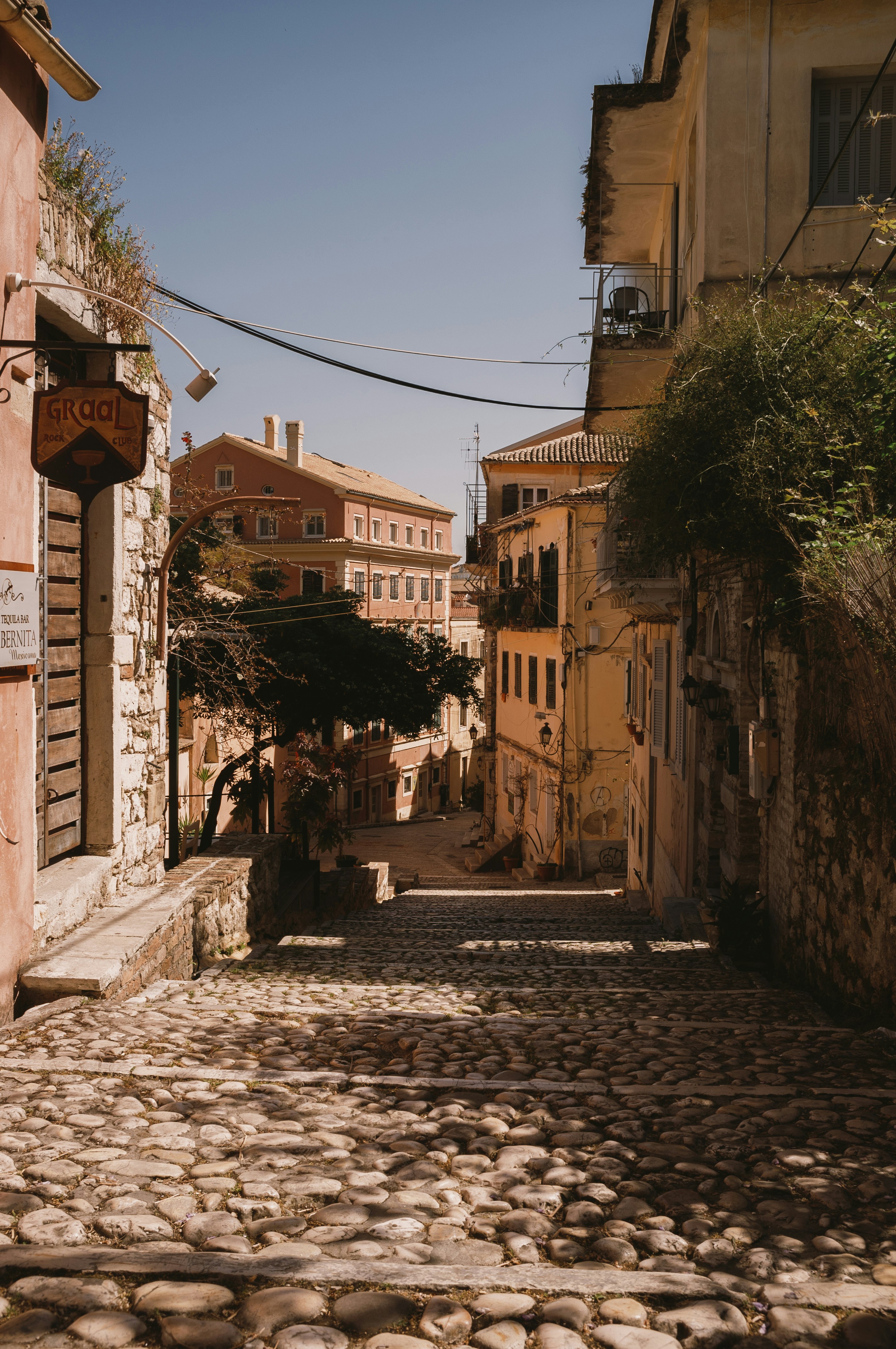 Cobblestone alleyway lined with traditional buildings in Corfu Old Town, Greece