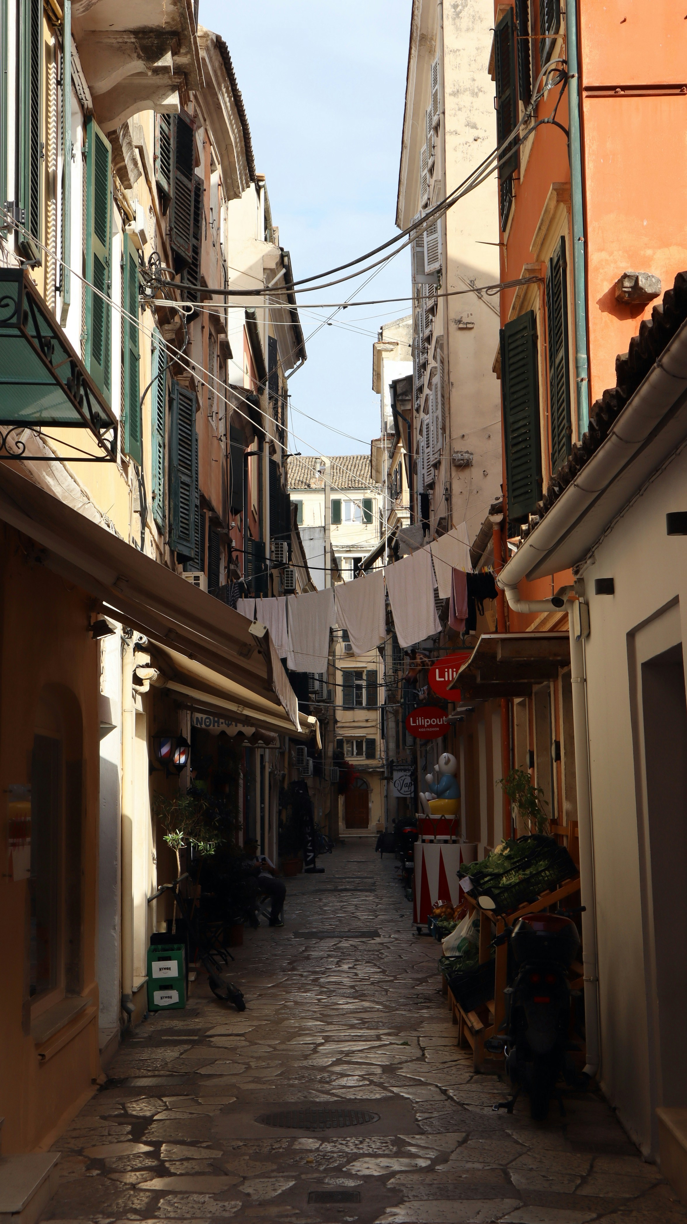 Narrow cobblestone alley in Corfu Old Town with Venetian architecture