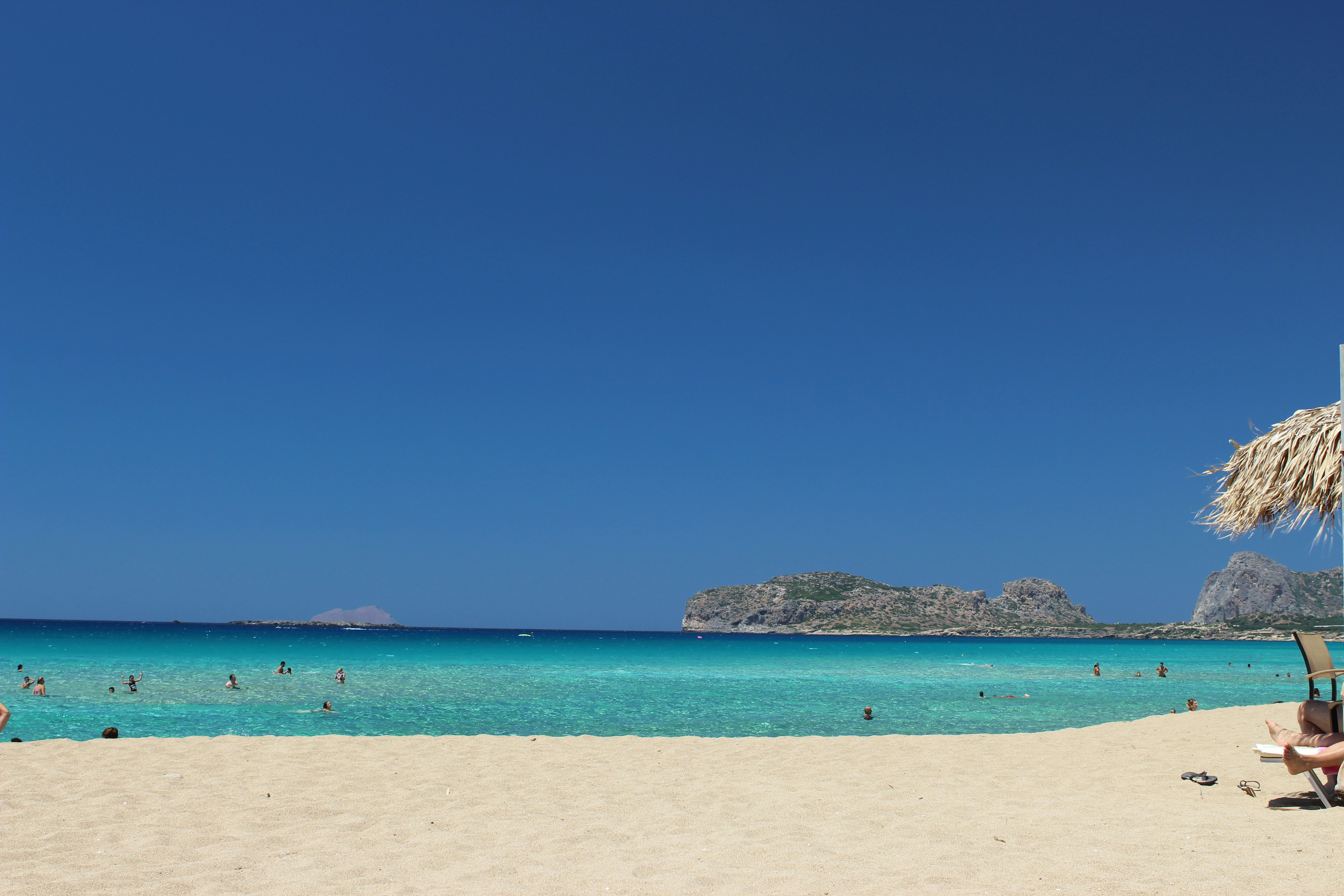 Sandy beach with turquoise water and rocky islets in the distance, Crete, Greece