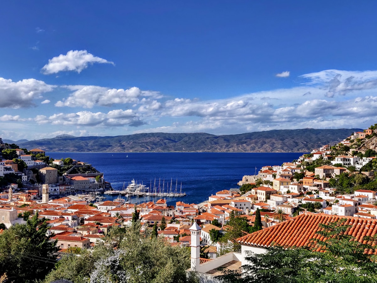 Aerial view of Hydra town with terracotta-roofed stone mansions and the horseshoe harbour, Greece