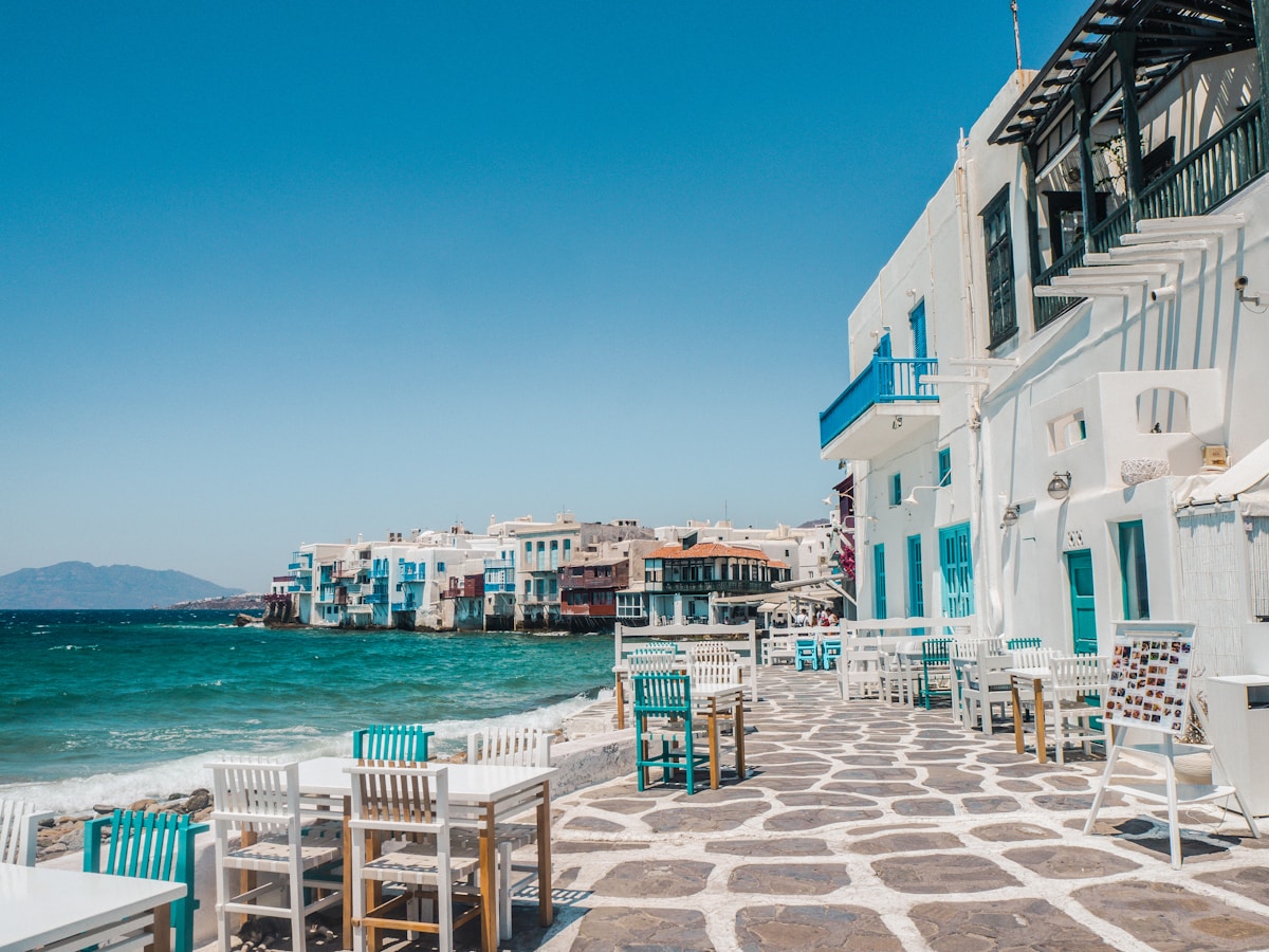 Whitewashed windmills and blue sea in Mykonos with Little Venice in the background