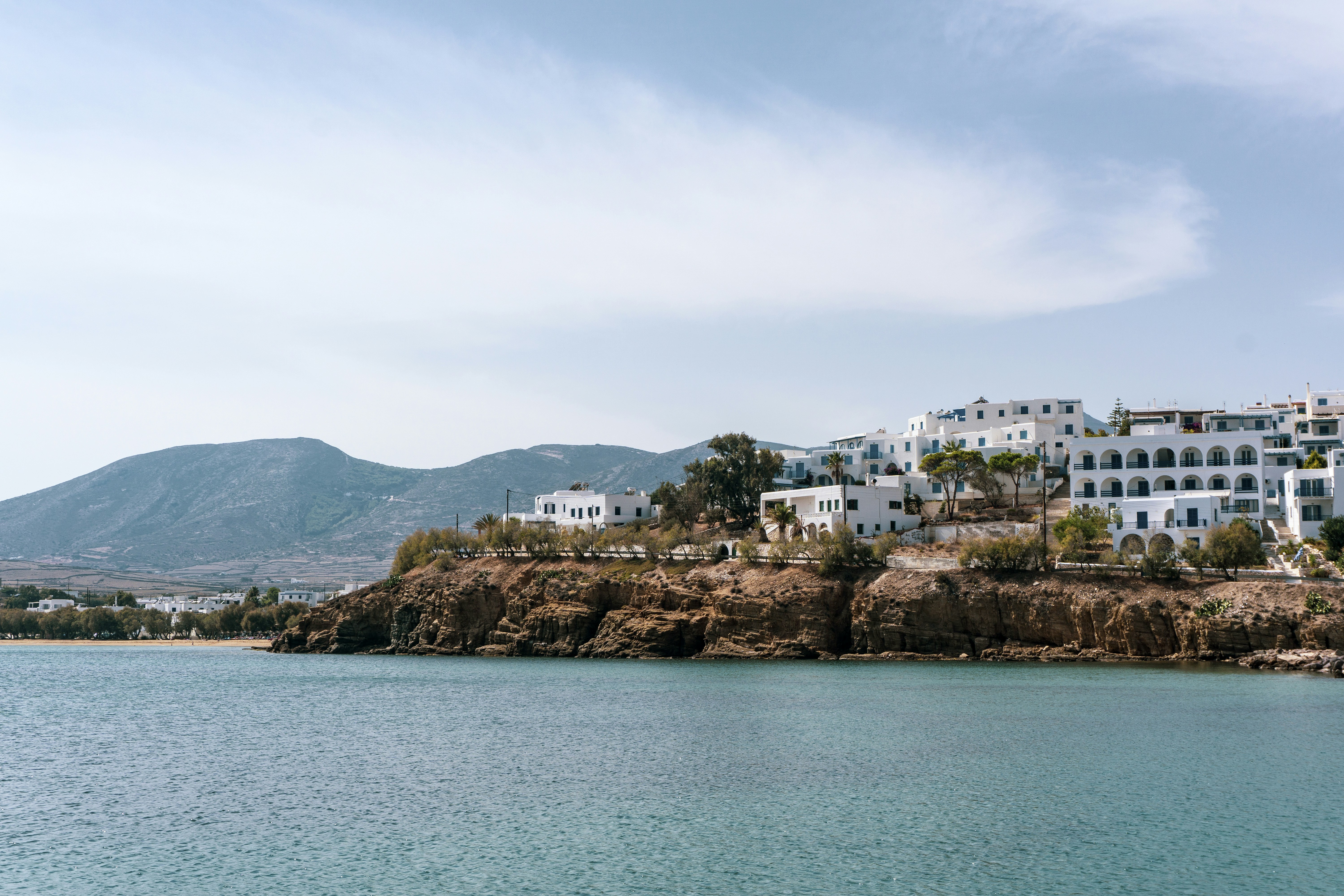 Clear turquoise water at a sandy beach on Paros with granite rock formations