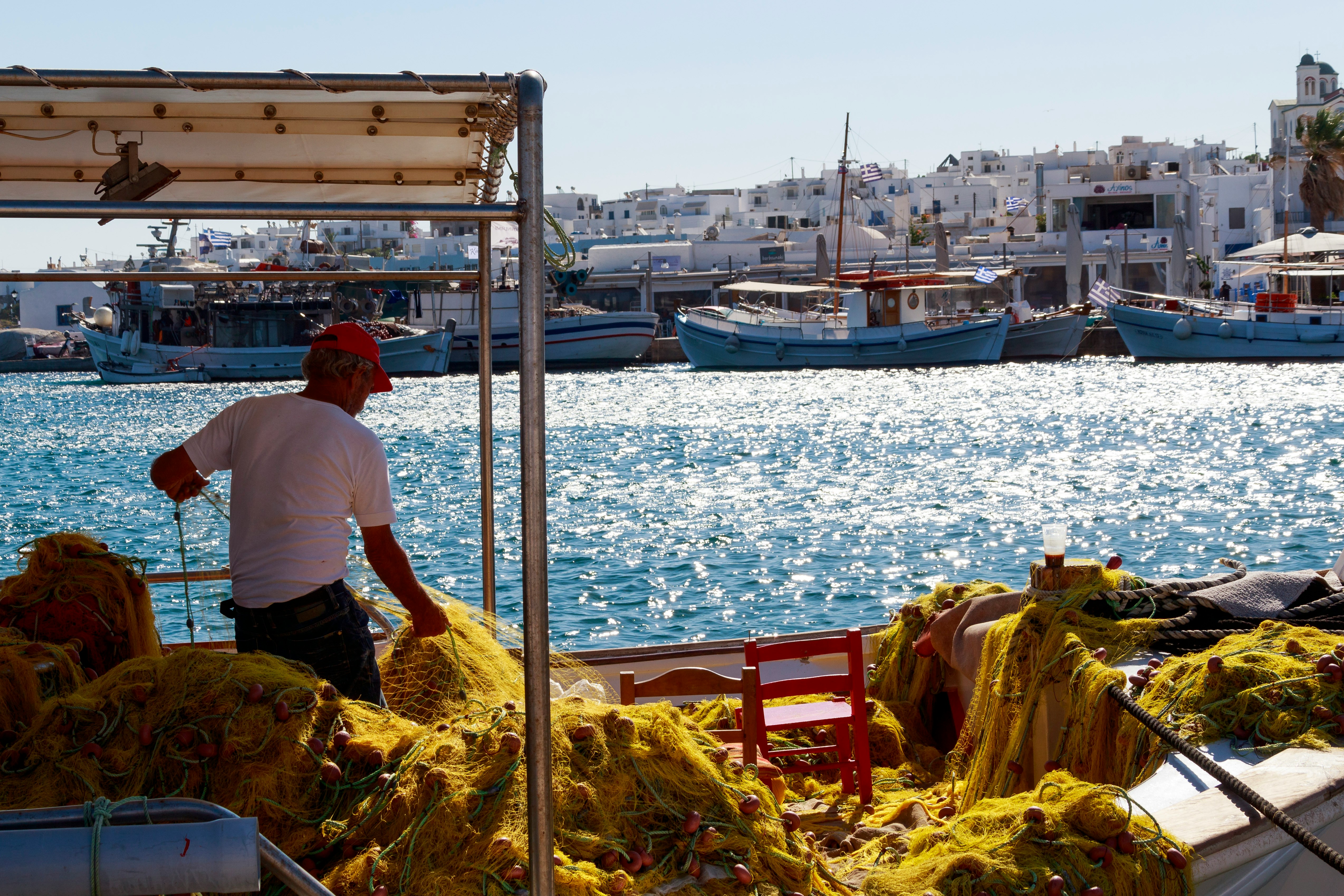 Seafood dishes on a taverna table overlooking Naoussa harbour, Paros