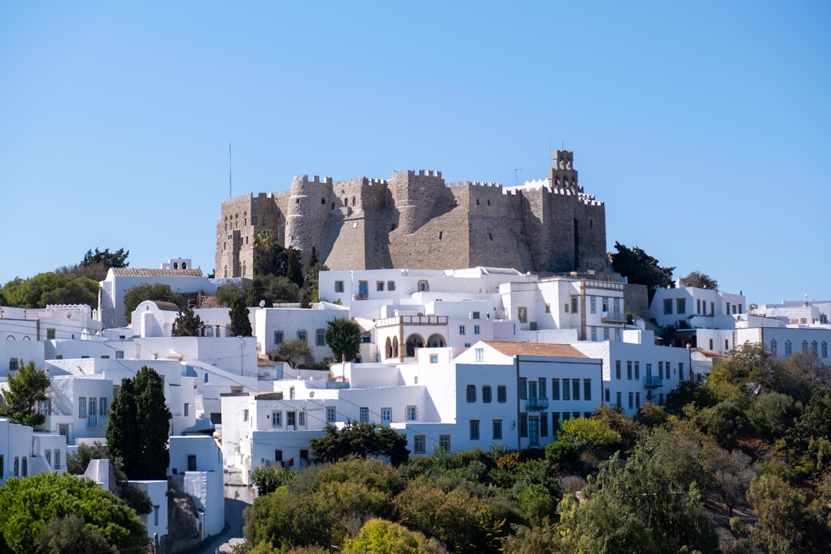 The medieval fortress walls of the Monastery of Saint John above the white mansions of Chora village, Patmos, Greece