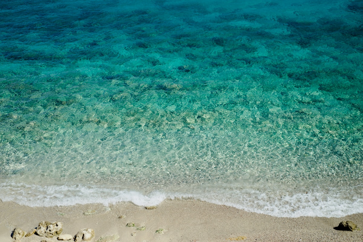 Clear turquoise water at Anthony Quinn Bay, Rhodes with rocky cliffs