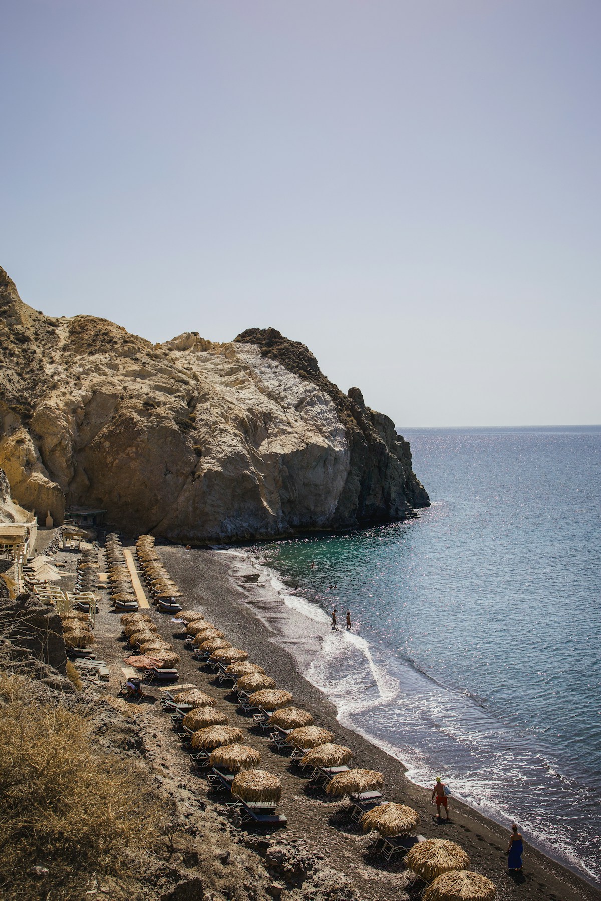 Red volcanic cliffs above the black sand beach at Perissa, Santorini