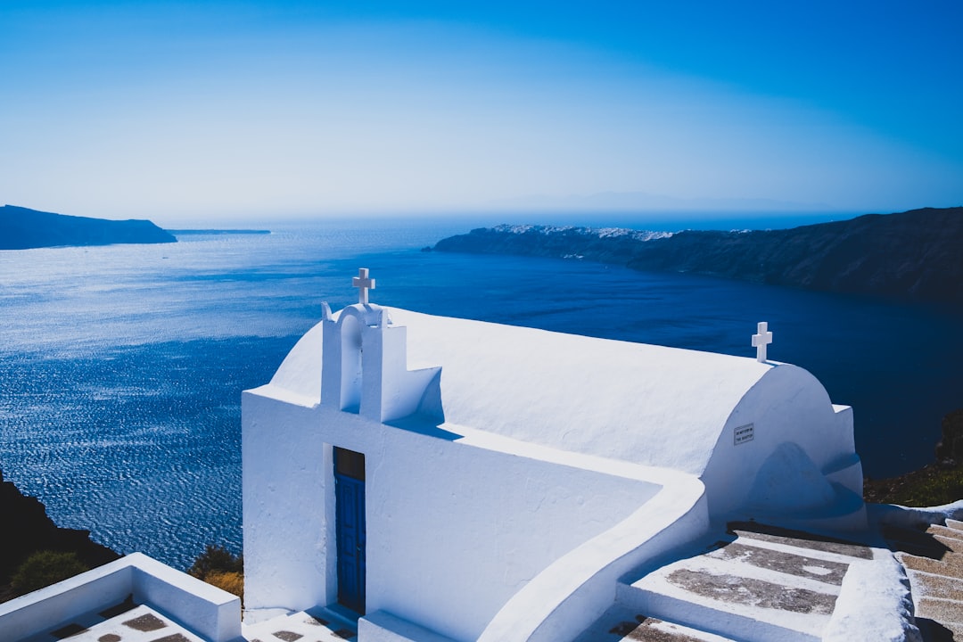 White chapel with blue door on the caldera rim, Imerovigli, Santorini, Greece