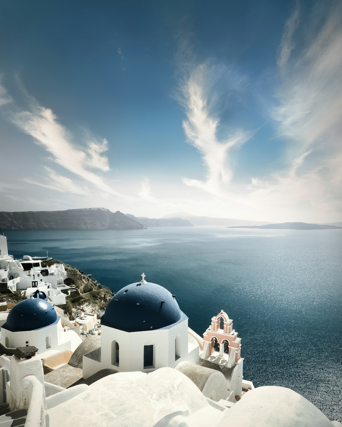 Iconic blue-domed churches in Oia, Santorini with caldera views