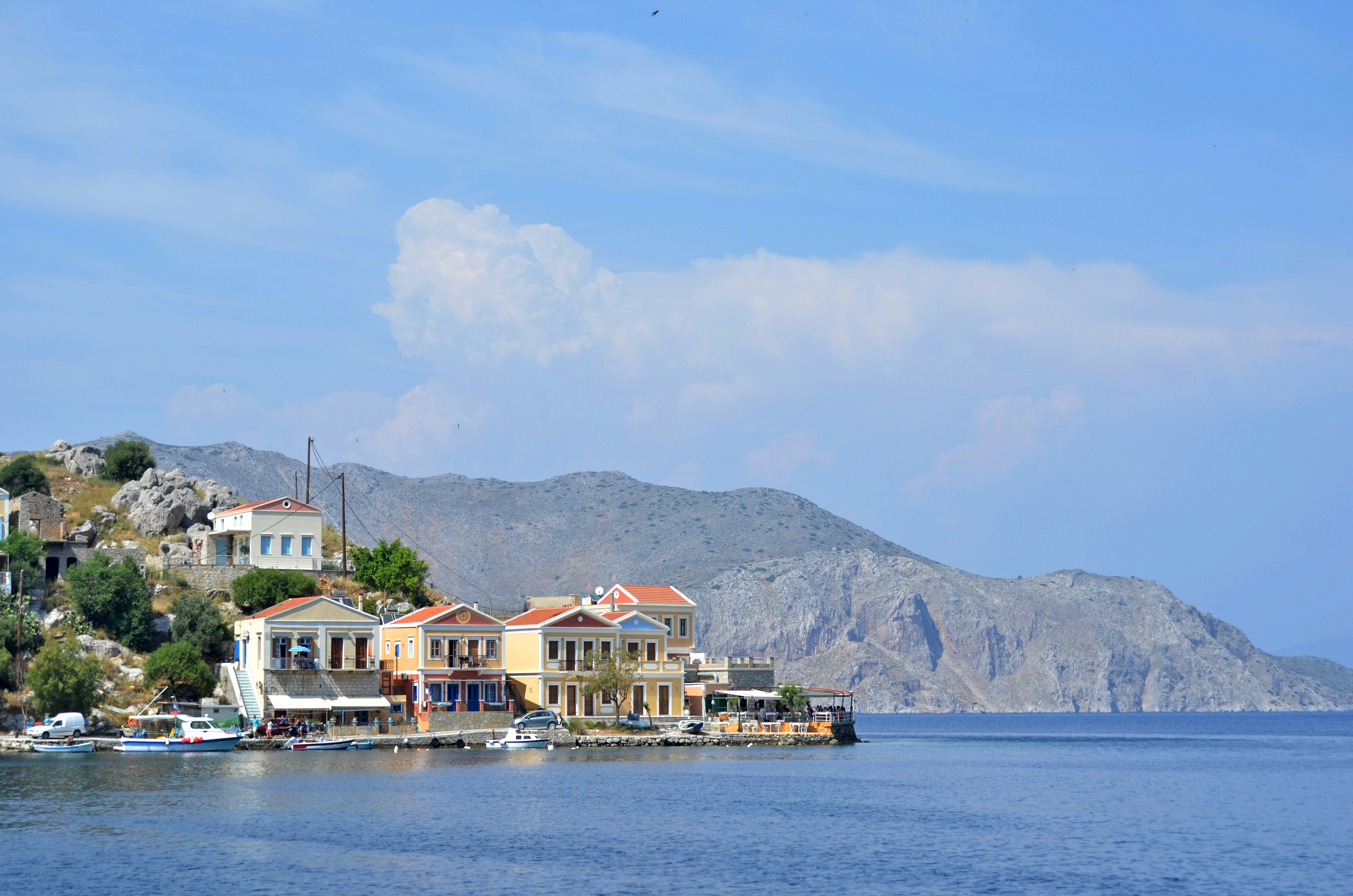 Colourful neoclassical houses with terracotta roofs beside the harbour, Symi, Dodecanese, Greece