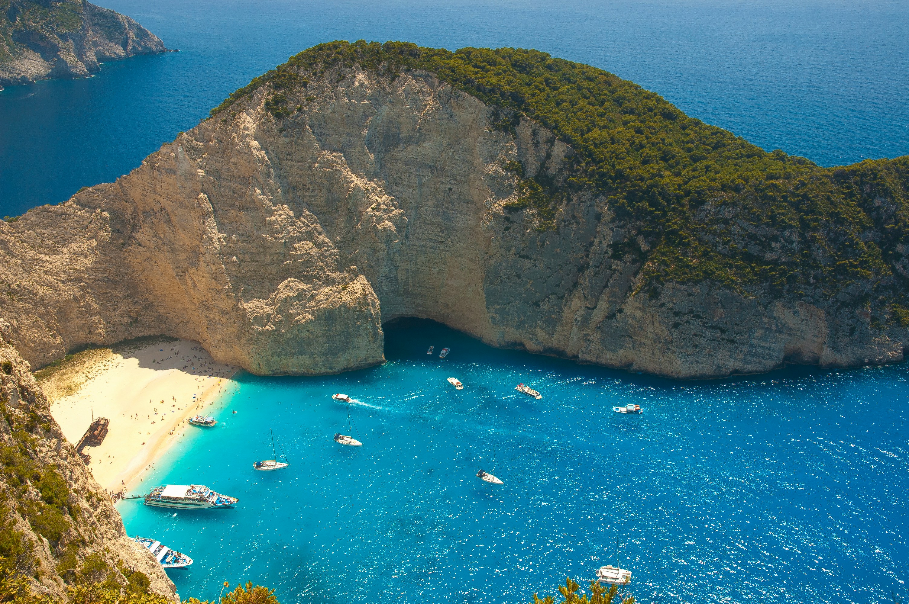 Aerial view of Navagio Shipwreck Beach, Zakynthos, with white sand and turquoise water enclosed by limestone cliffs