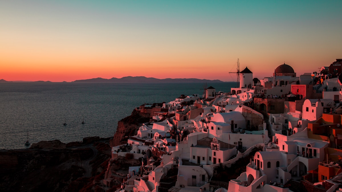 Oia village at sunset with white windmill and Cycladic buildings, Santorini