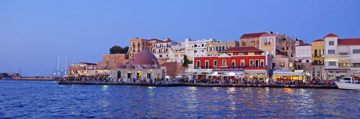 Chania harbour at dusk with waterfront buildings reflected in the water, Crete, Greece