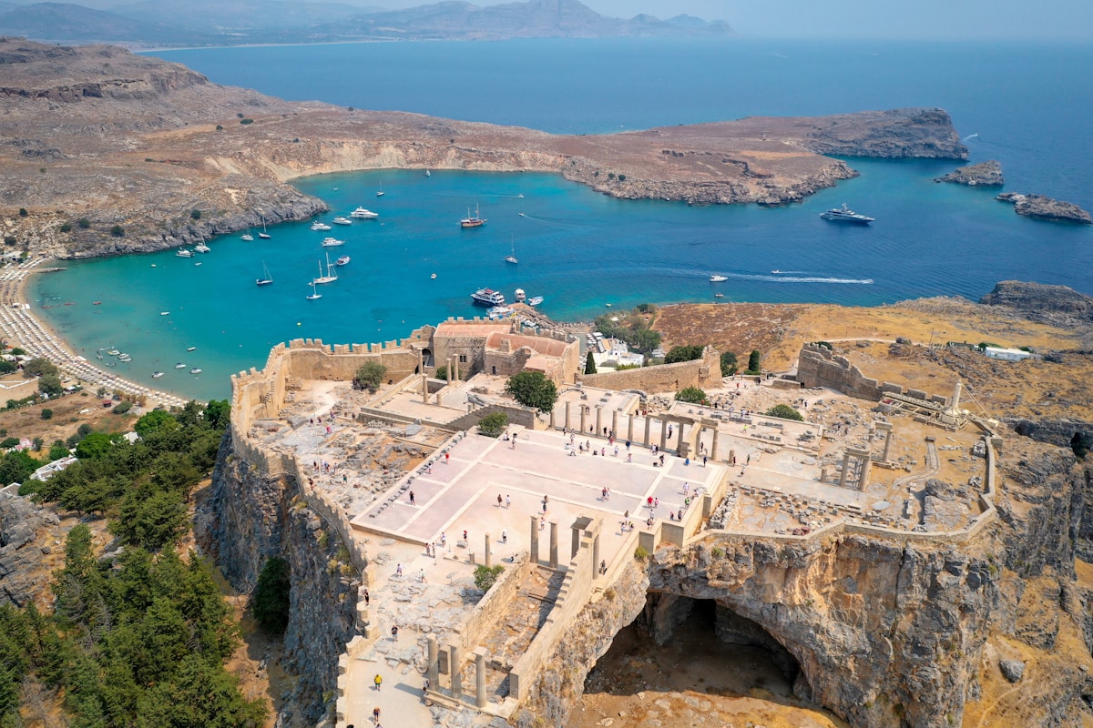 Aerial view of the ancient Acropolis of Lindos overlooking a turquoise bay, Rhodes, Greece
