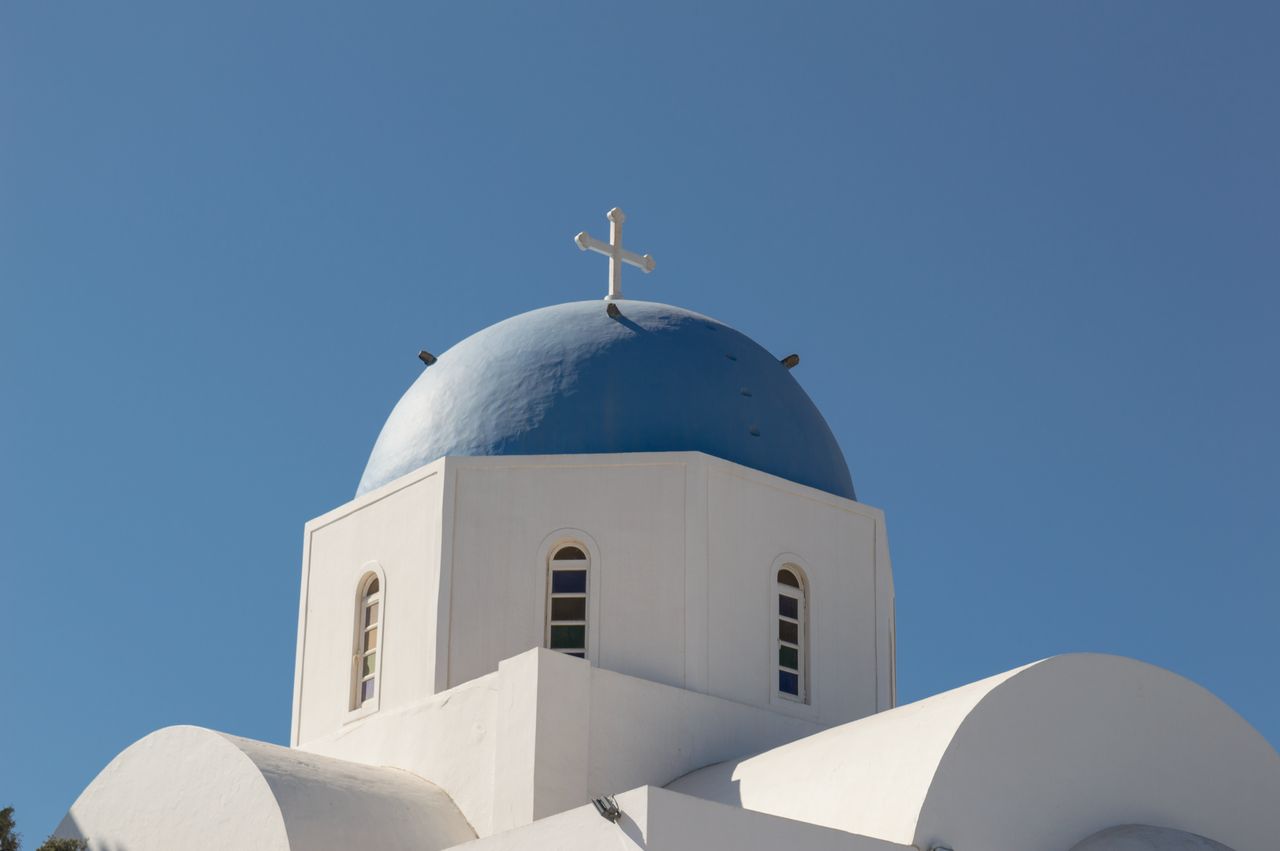Blue-domed Greek Orthodox church against bright blue sky, Fira, Santorini