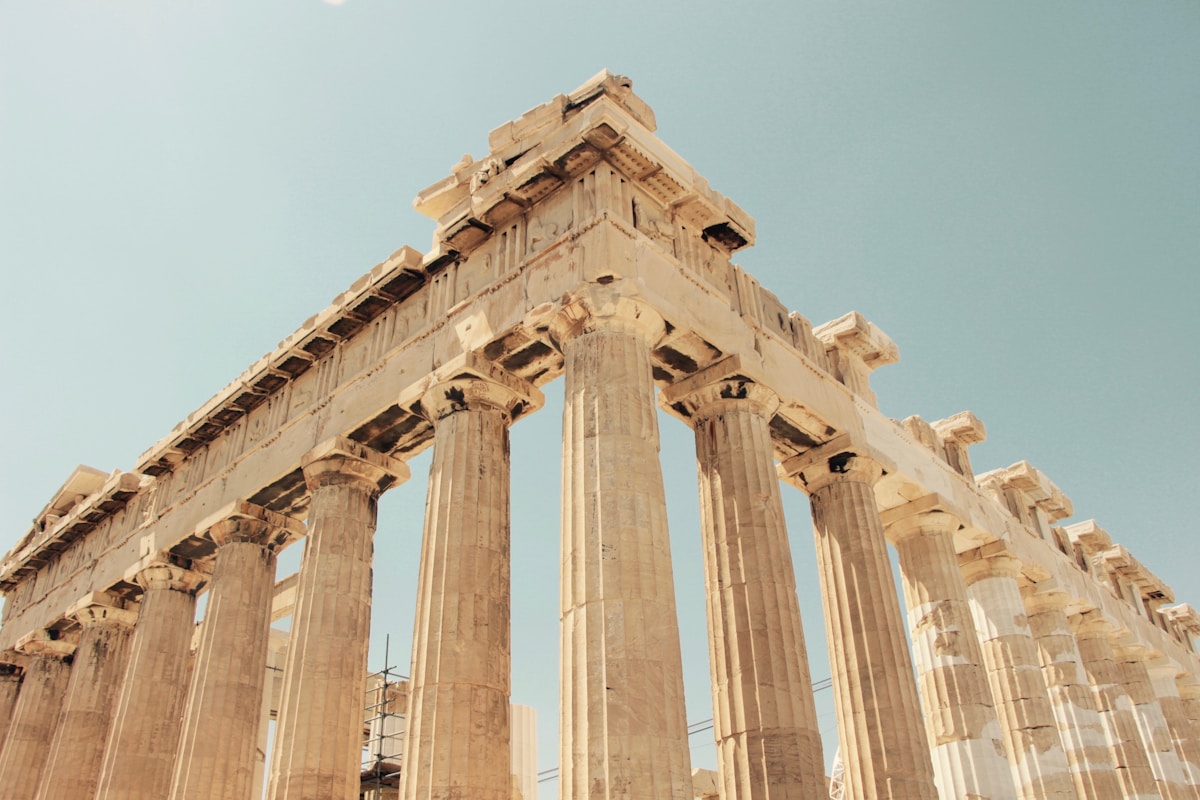 Low angle view of Parthenon columns against blue sky, Athens, Greece
