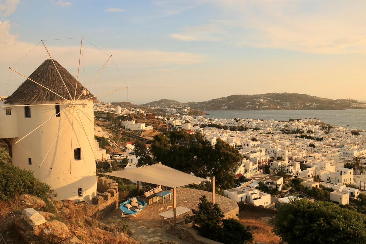 Windmill overlooking the white buildings of Mykonos Town at sunset