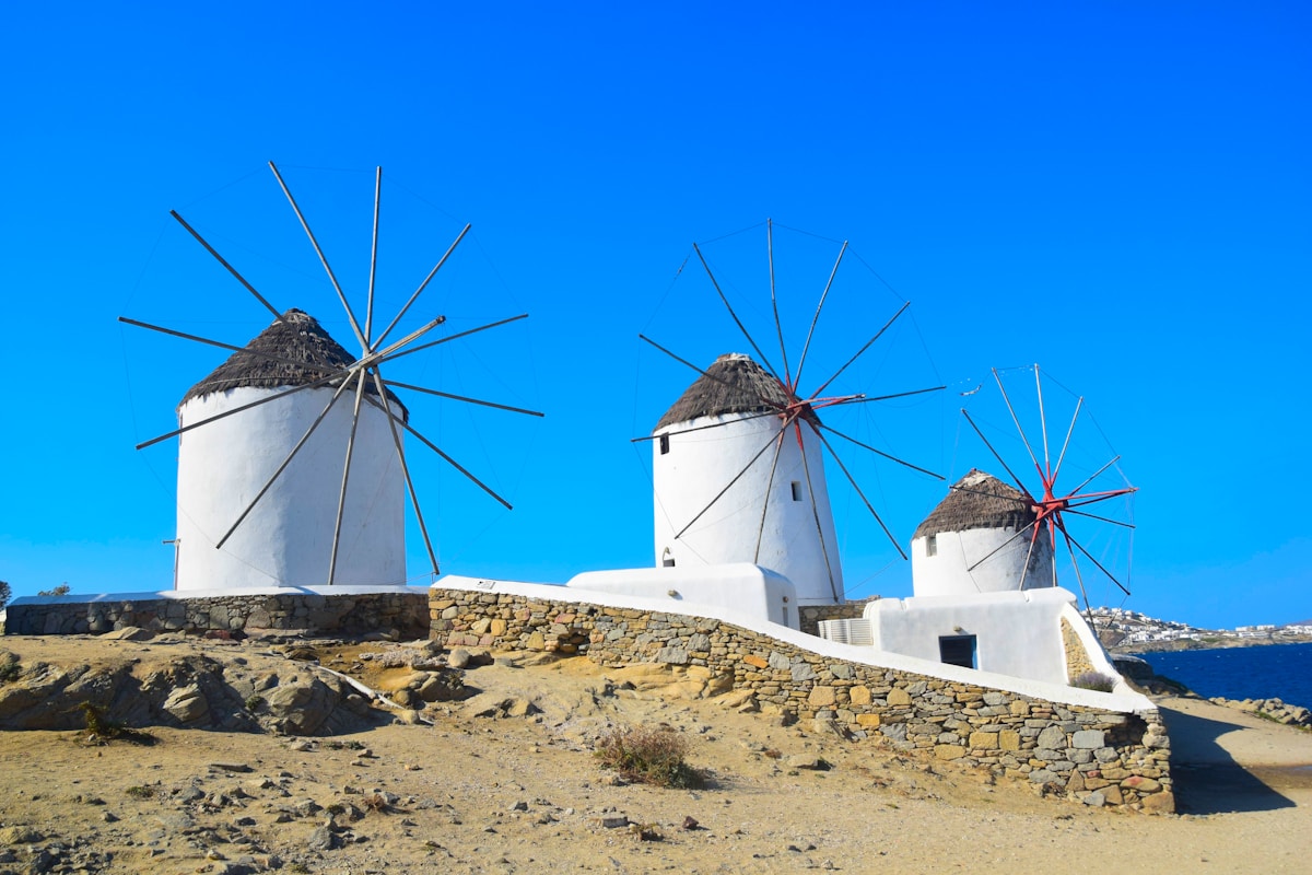 Three iconic white windmills on a hilltop above Mykonos town, Greece