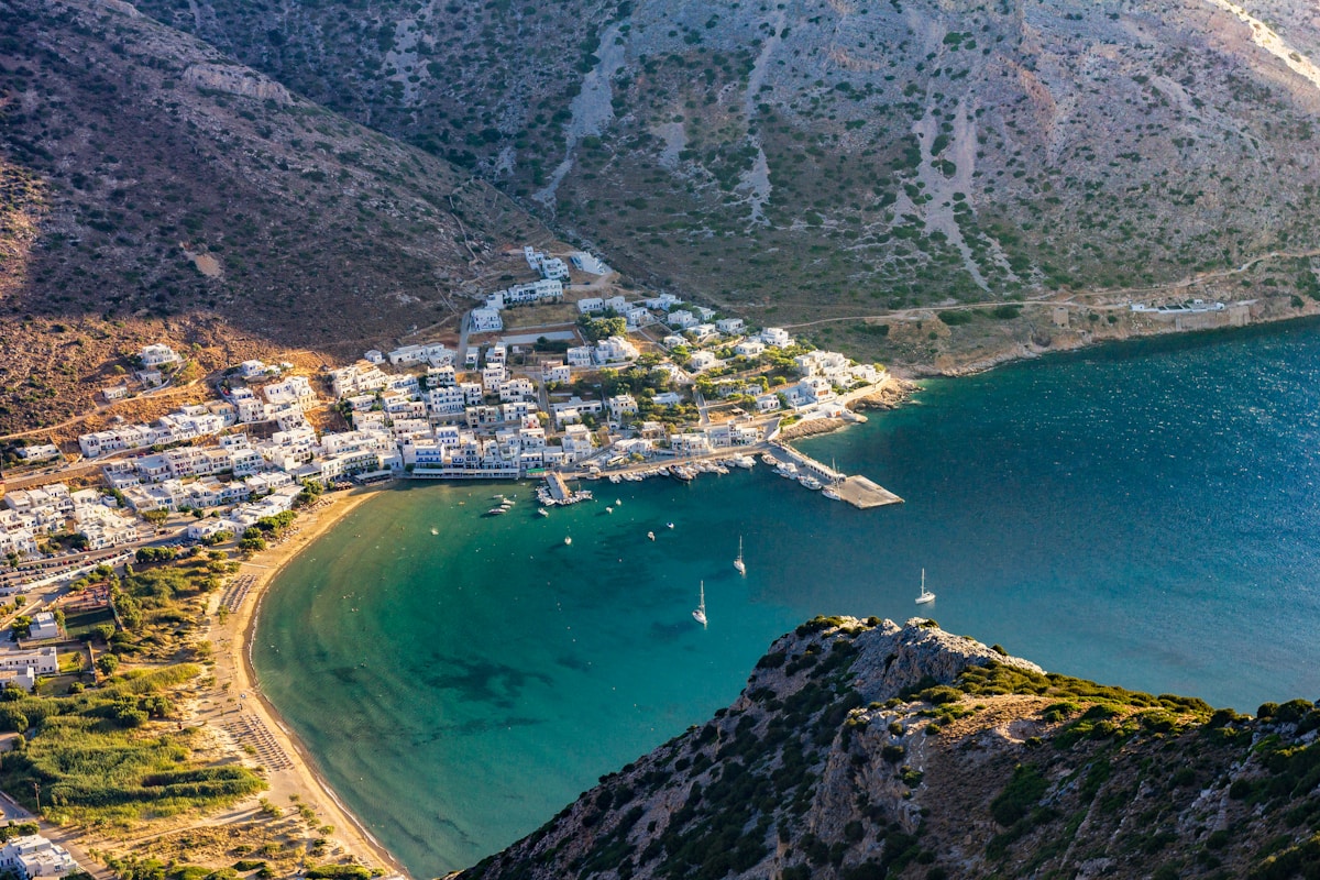 White hillside village in a turquoise bay surrounded by mountains, Greek island