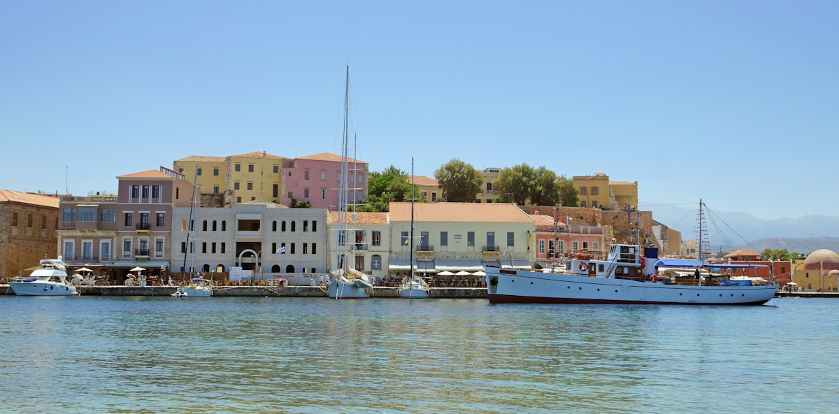 Chania Venetian harbour with colourful facades reflecting in the calm water on a clear summer morning
