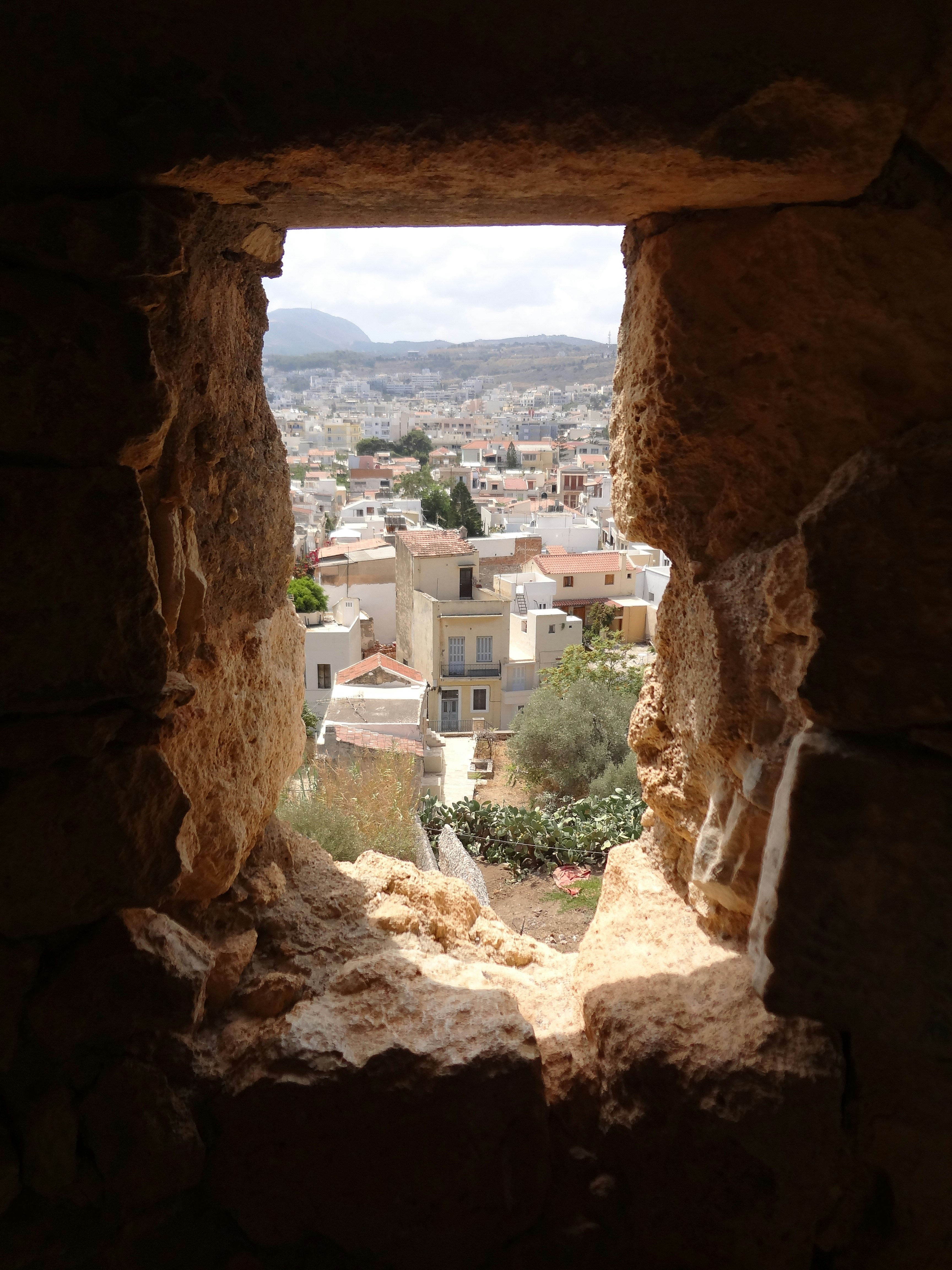 View of Rethymno town through a stone archway opening in the Venetian fortress, Crete, Greece