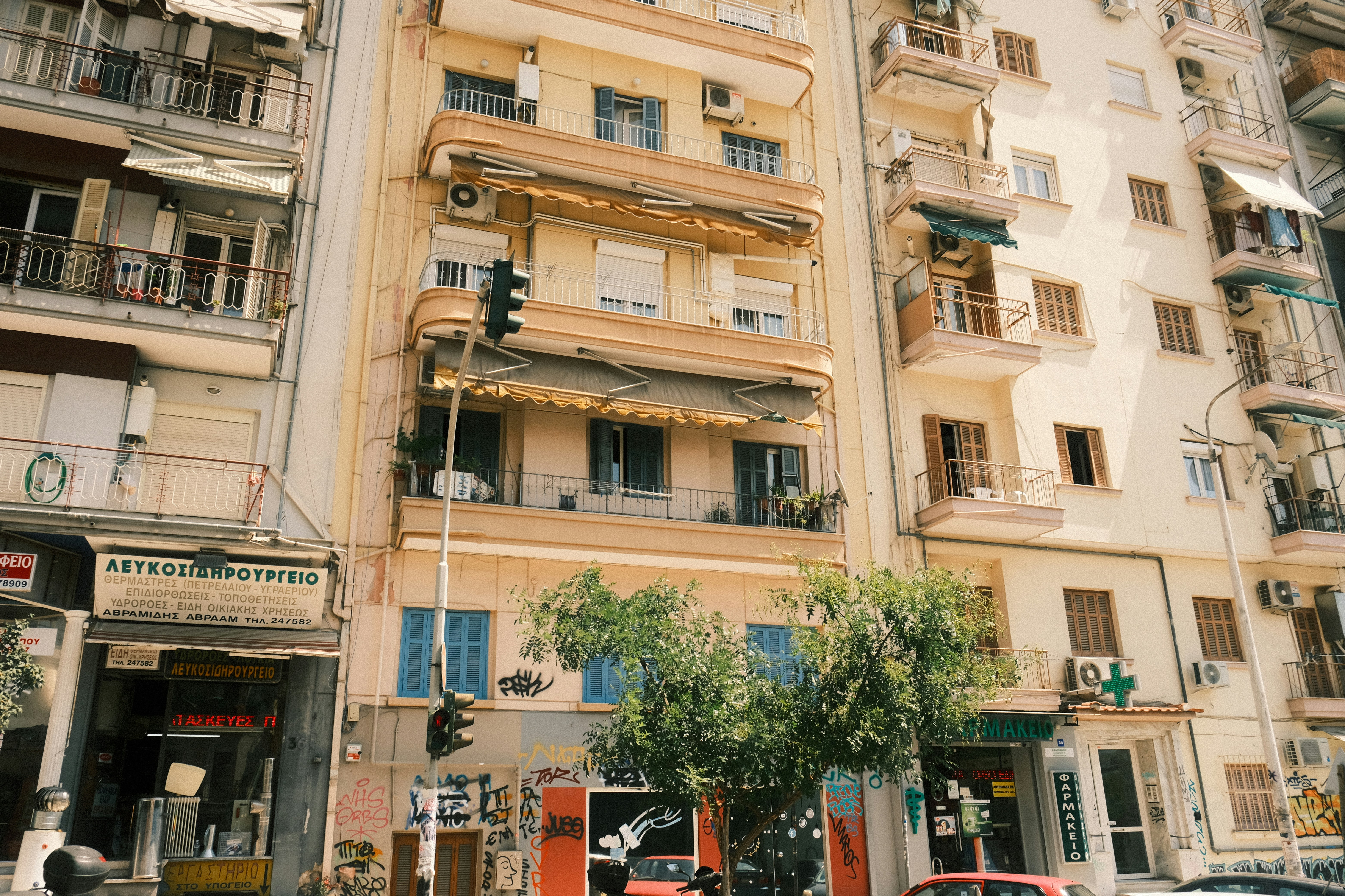 Apartment buildings with balconies and shops on a residential street in Thessaloniki, Greece