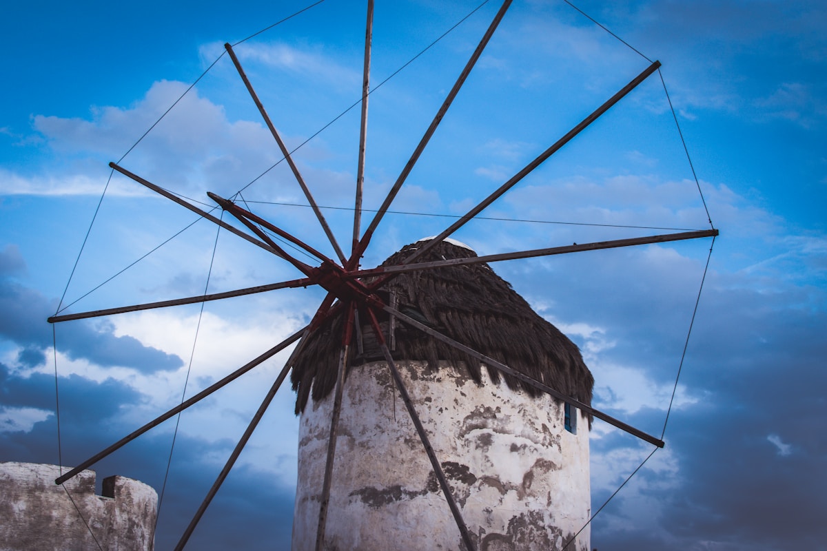 The iconic white stone windmill of Mykonos against a blue cloudy sky